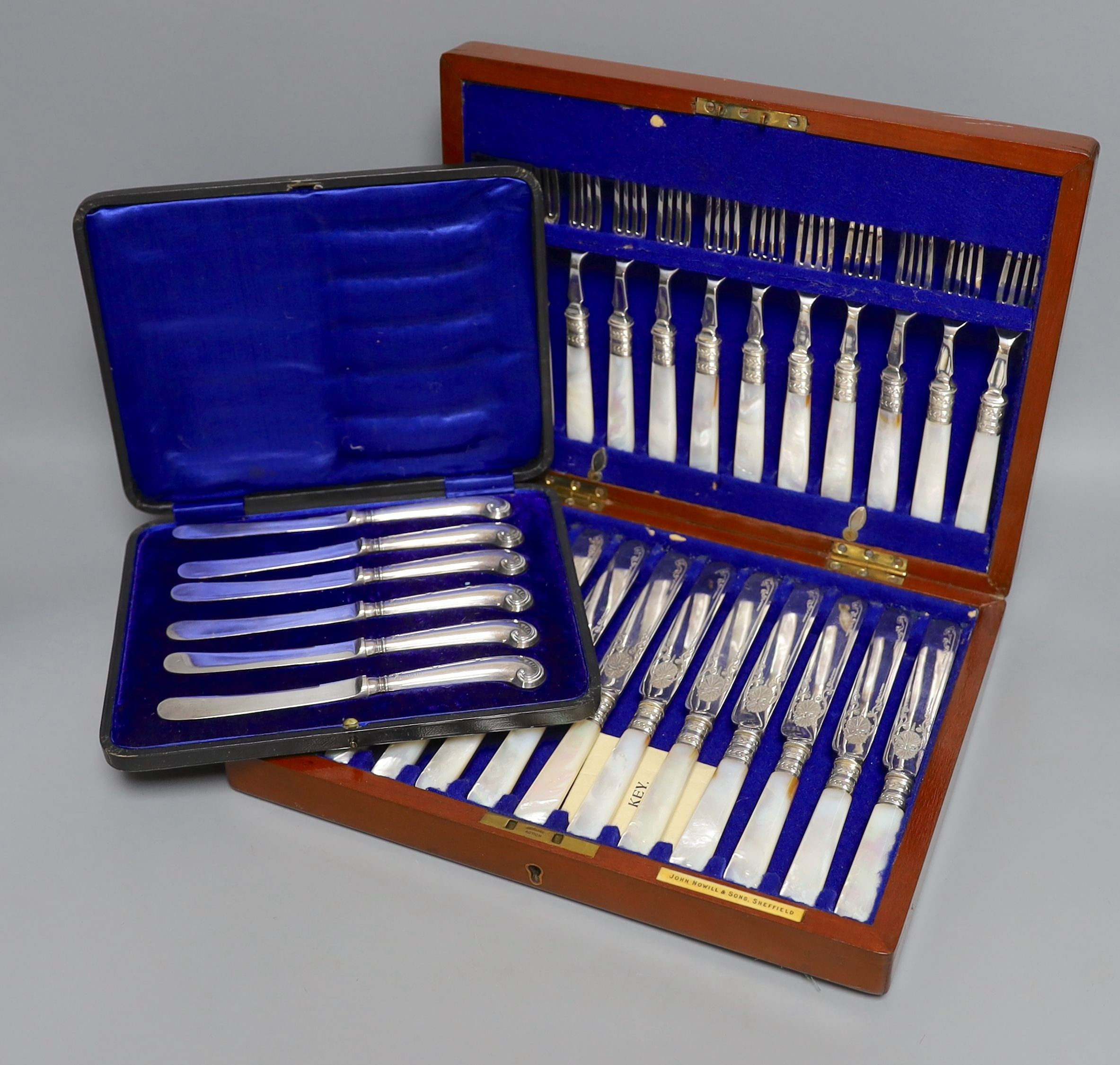 A cased set of silver handled pistol knives and a cased set of mother-of-pearl fruit knives and forks